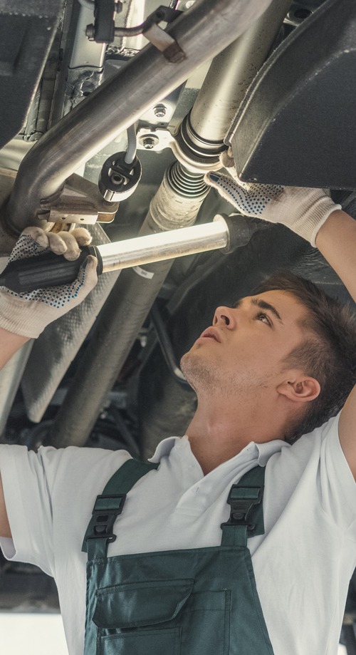 Mechanic checking underneath a vehicle - MOT Testing Northampton